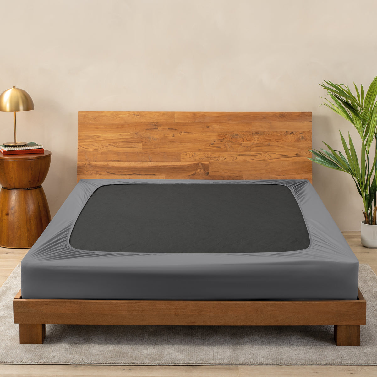 A cover on a box spring set on a wooden bed frame