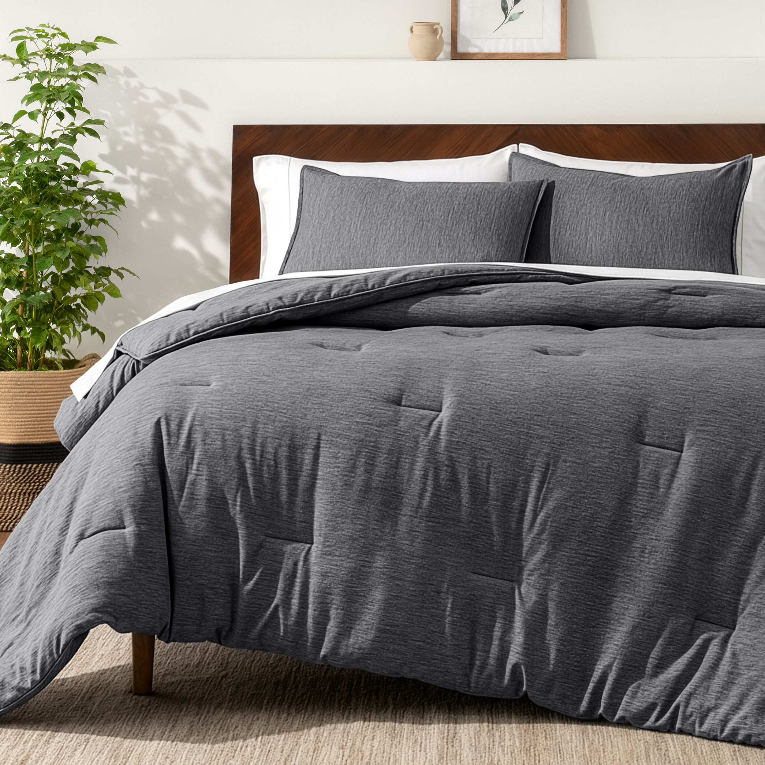 Bedding set on a bed in a bedroom with a side table and lamp.