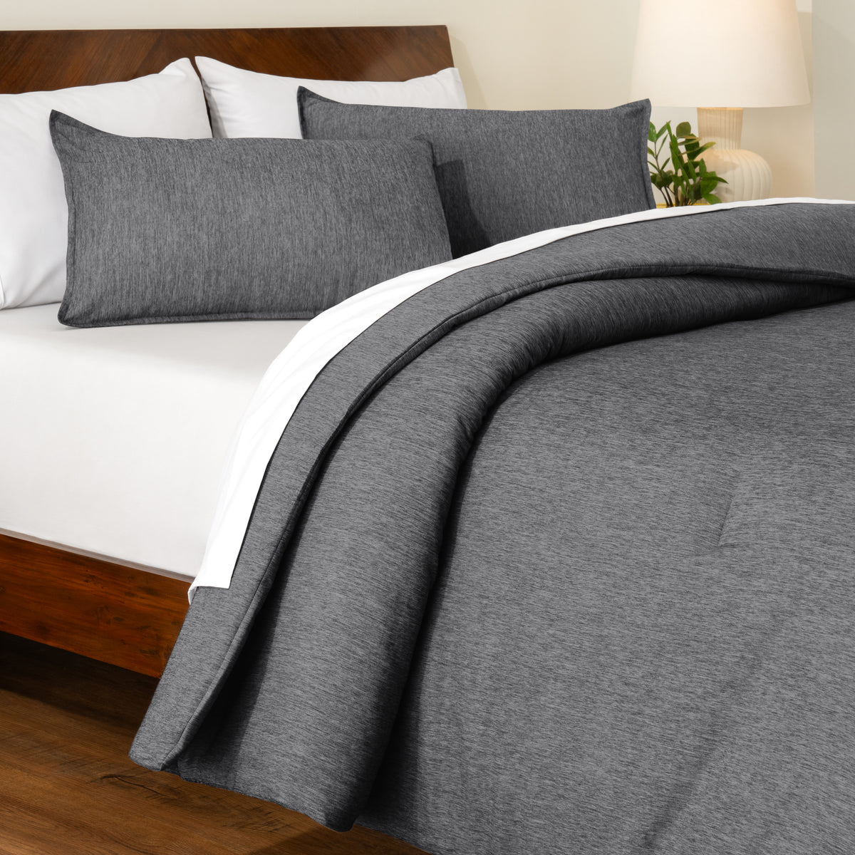 Track stitch comforter on a bed with white pillows and a wooden headboard.