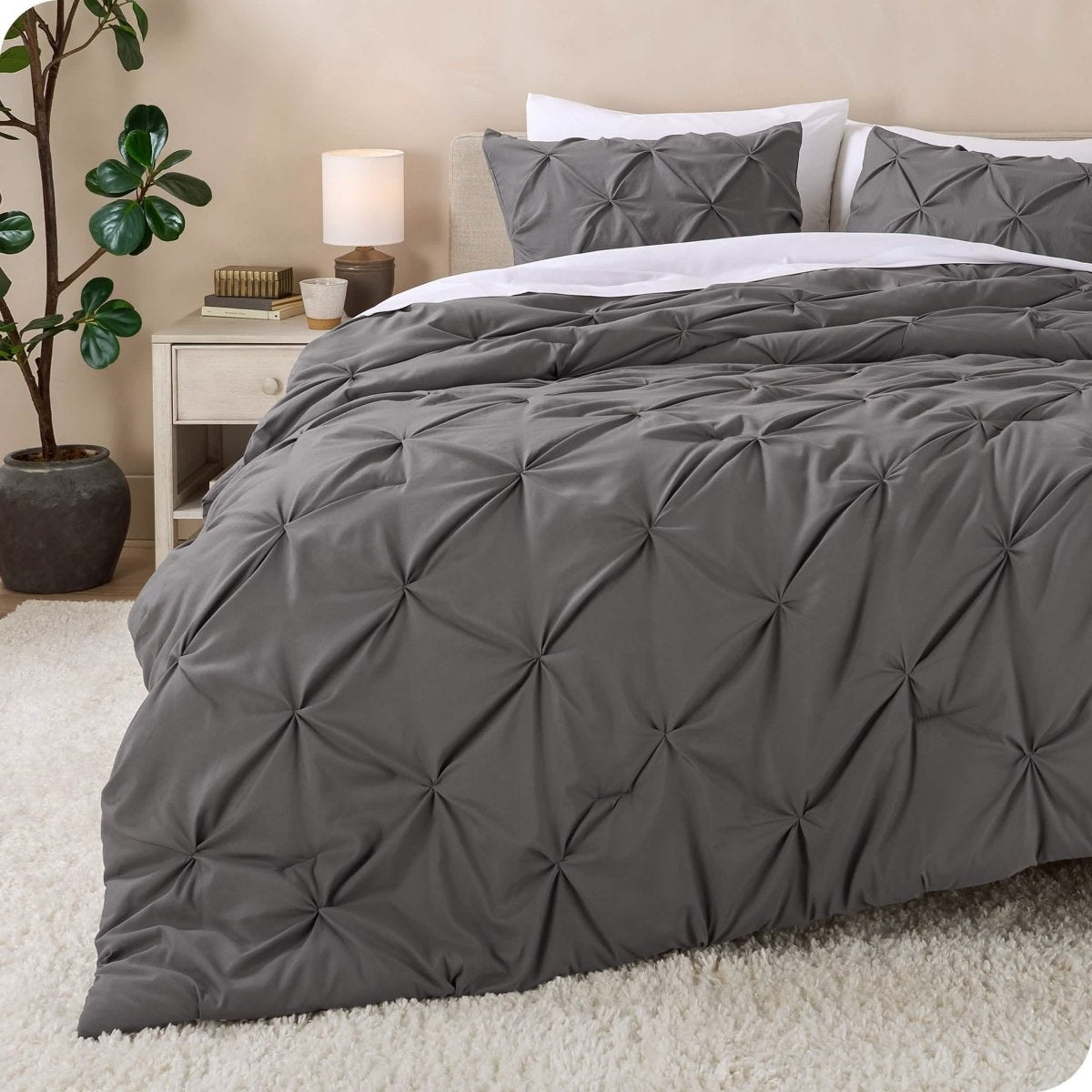 A bed made with a grey pintuck comforter set
