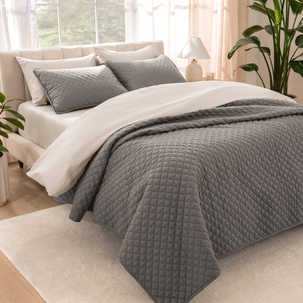 Bedroom showing coverlet set laying on the bed with the quilt folded over on itself