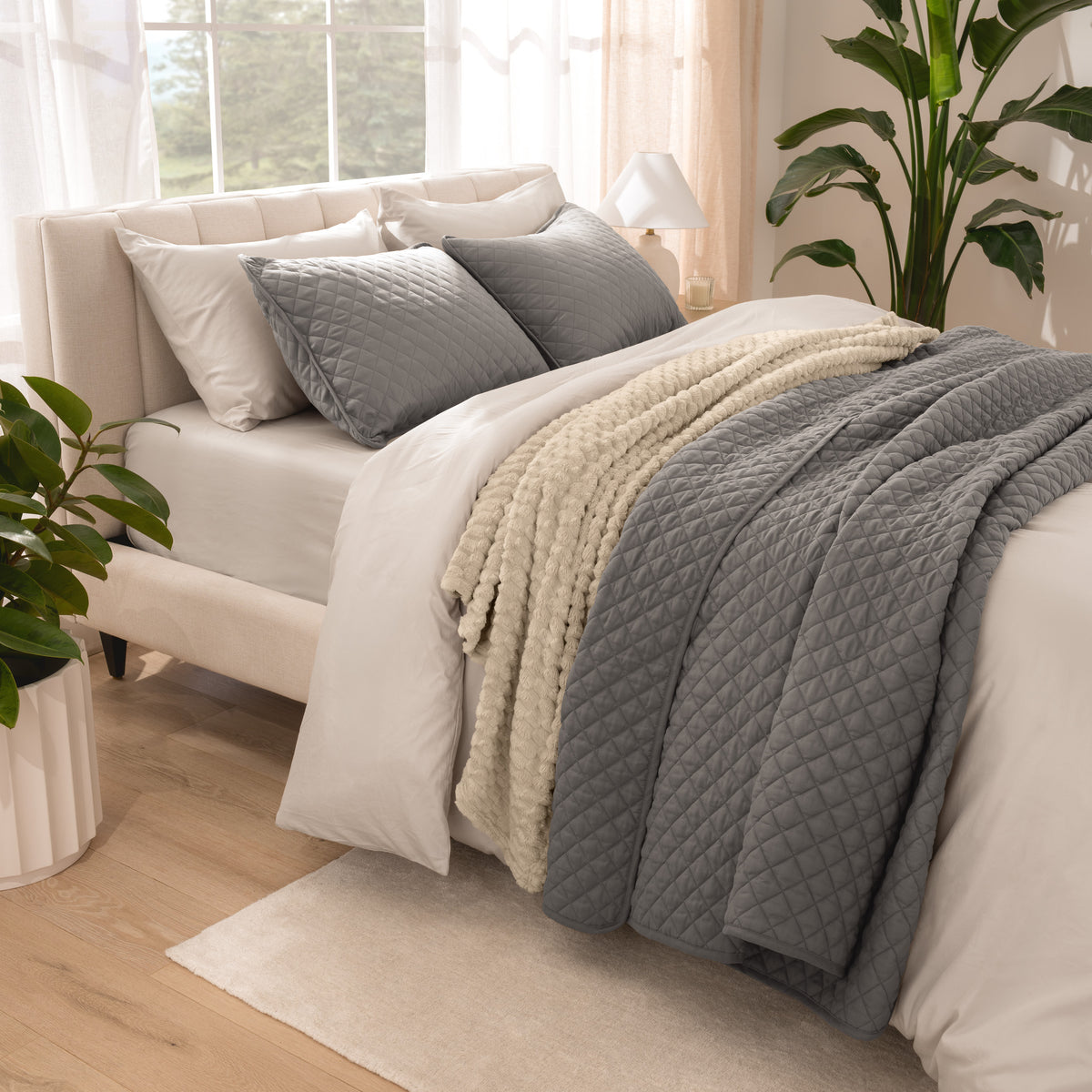 Side view of bed with coverlet set draped on a bed made with a duvet set