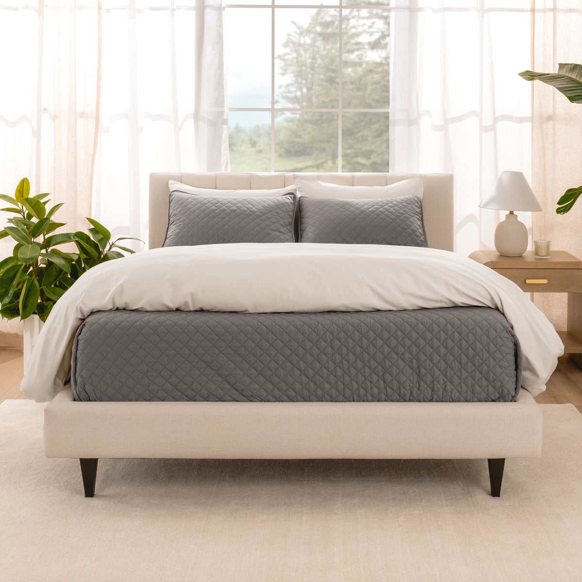A bright bedroom with a coverlet set on the bed
