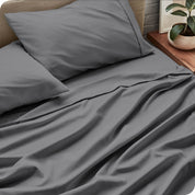Close up of grey sheets and matching pillowcases on a bed