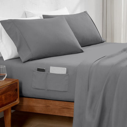 Gray bed sheets with pockets on a bed in a bedroom setting.