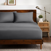 A bed dressed in a fitted sheet and two matching pillowcases.