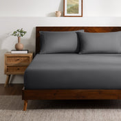 A bed made with a single fitted sheet and two matching pillowcases.