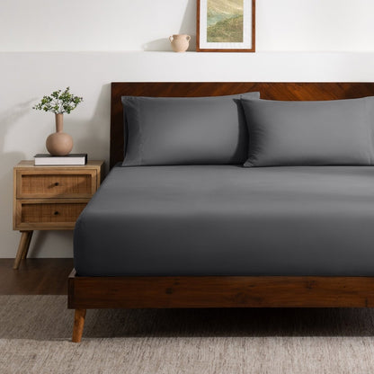 A bed made with a single fitted sheet and two matching pillowcases.