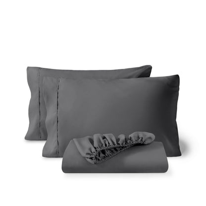 Pillowcases and a matching fitted sheet folded in front, shown on a plain white background.