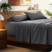 Bed with microfiber bedding and wooden headboard in a bedroom setting