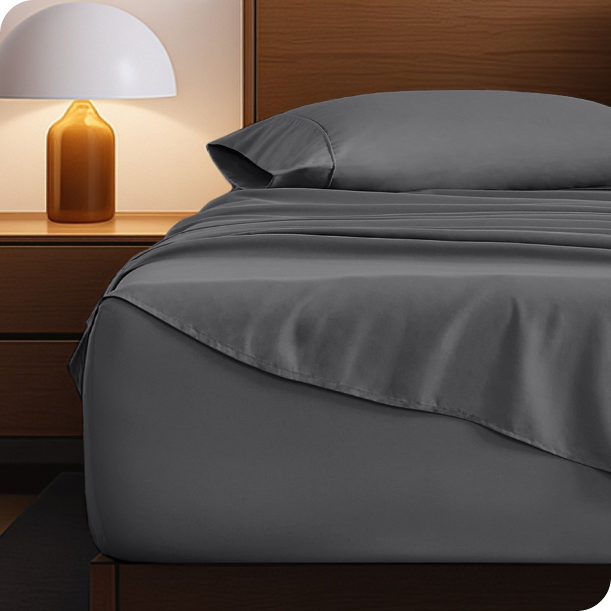 Microfiber bed sheets on a neatly made bed with a wooden headboard and nightstand.
