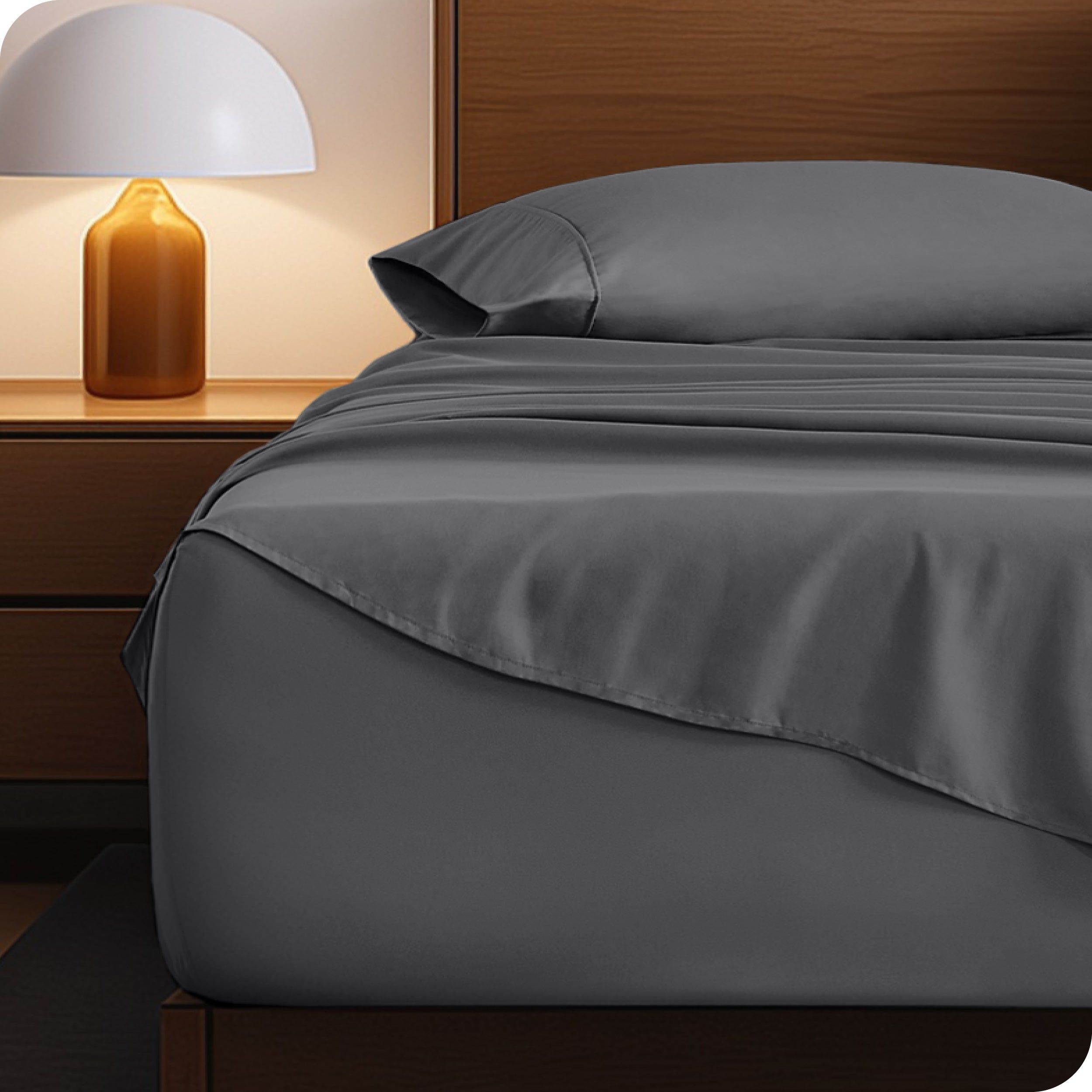 Microfiber bed sheets on a neatly made bed with a wooden headboard and nightstand.