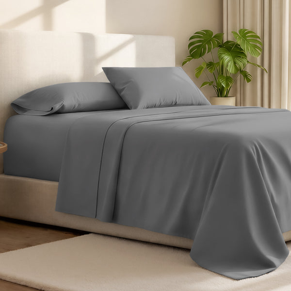 Microfiber bed sheets on a neatly made bed with a wooden headboard and nightstand.