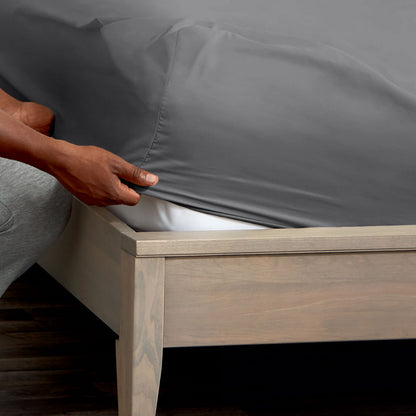 Person adjusting a fitted sheet on a mattress