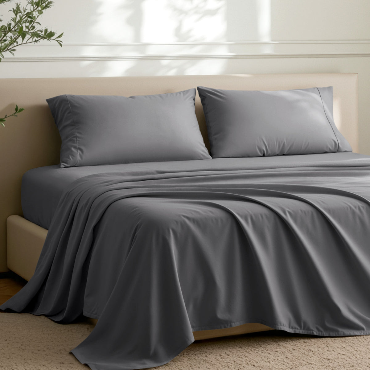Microfiber sheets on a bed in a well-lit room with a plant.