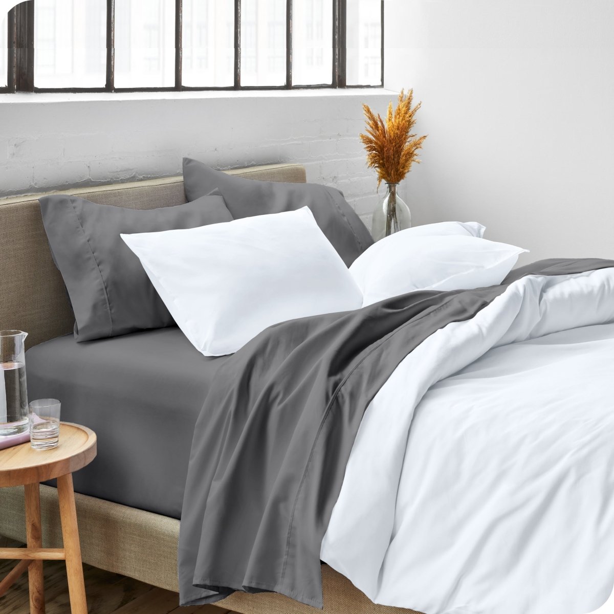 A side view of a bed made with microfiber sheets and a white duvet cover