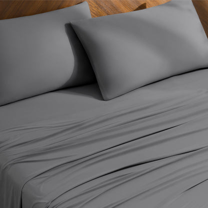 Bed sheets and pillowcases on a bed with a wooden headboard