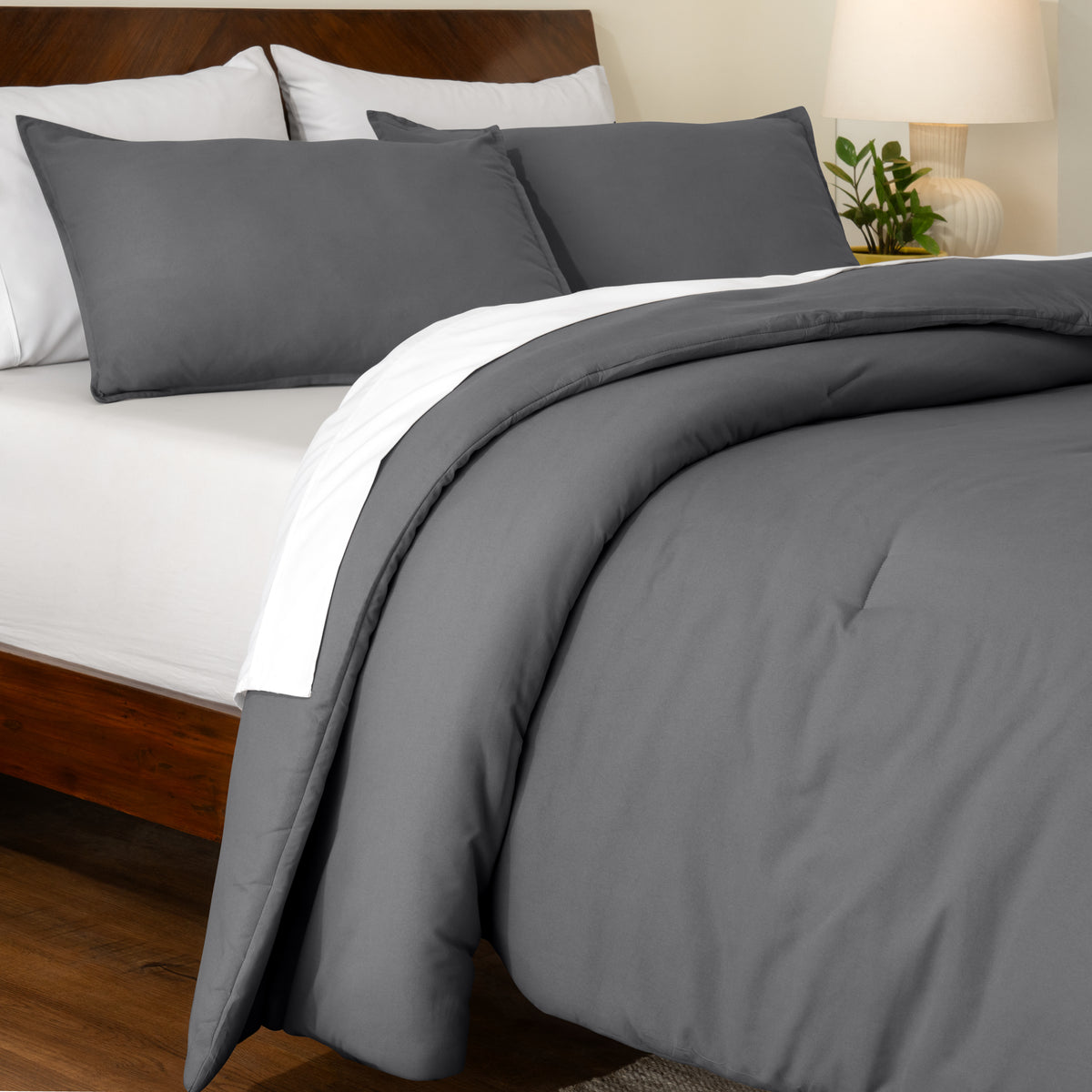 Track stitch comforter on a bed with white pillows and a wooden headboard.