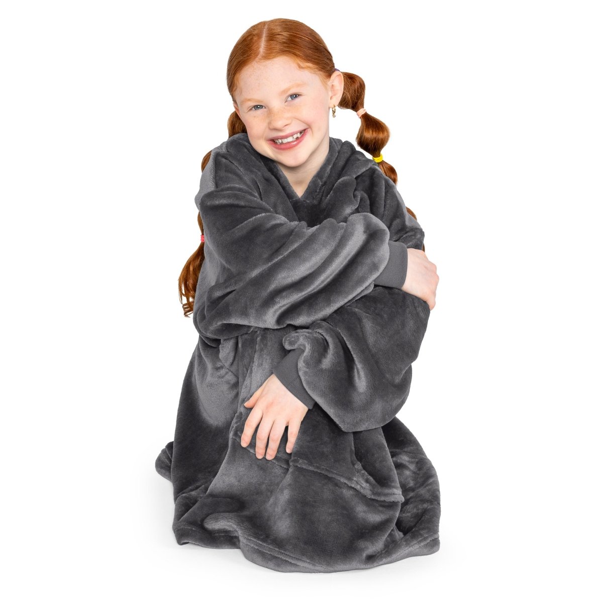A child is sitting with wearable blanket on