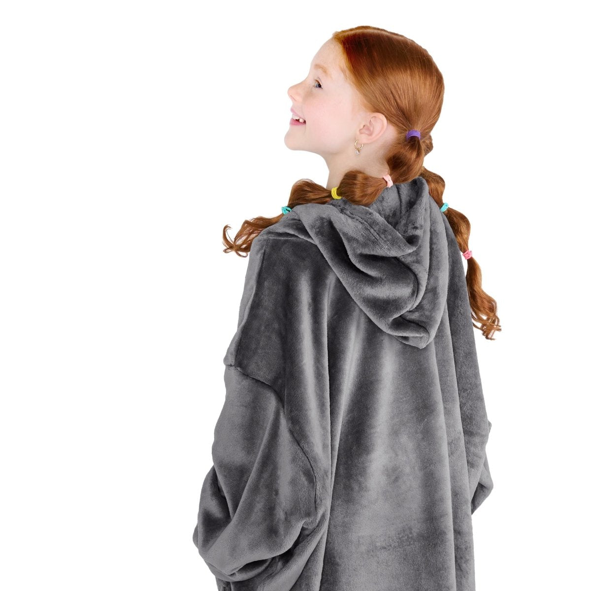 A girl has a microplush wearable blanket on