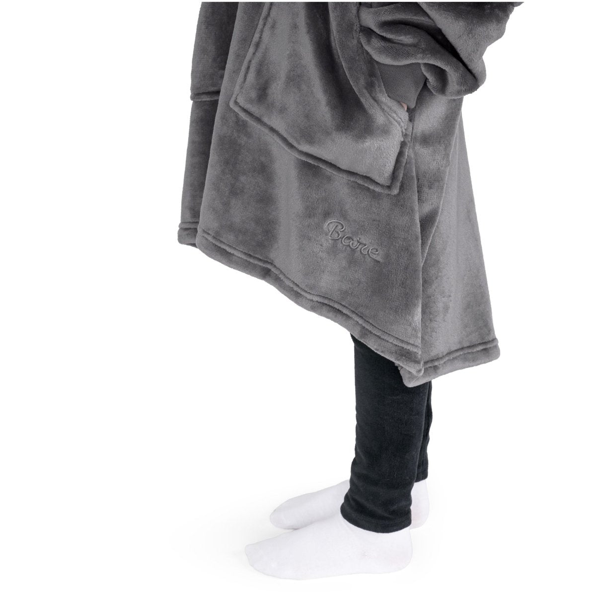 Close up of a child with her hand in the pocket of the wearable blanket she has on