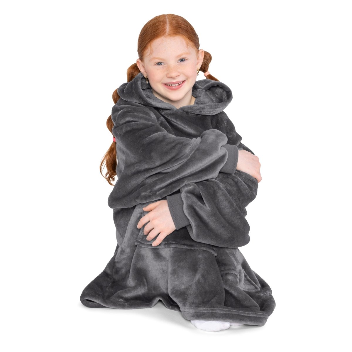 A child is sitting with wearable blanket on