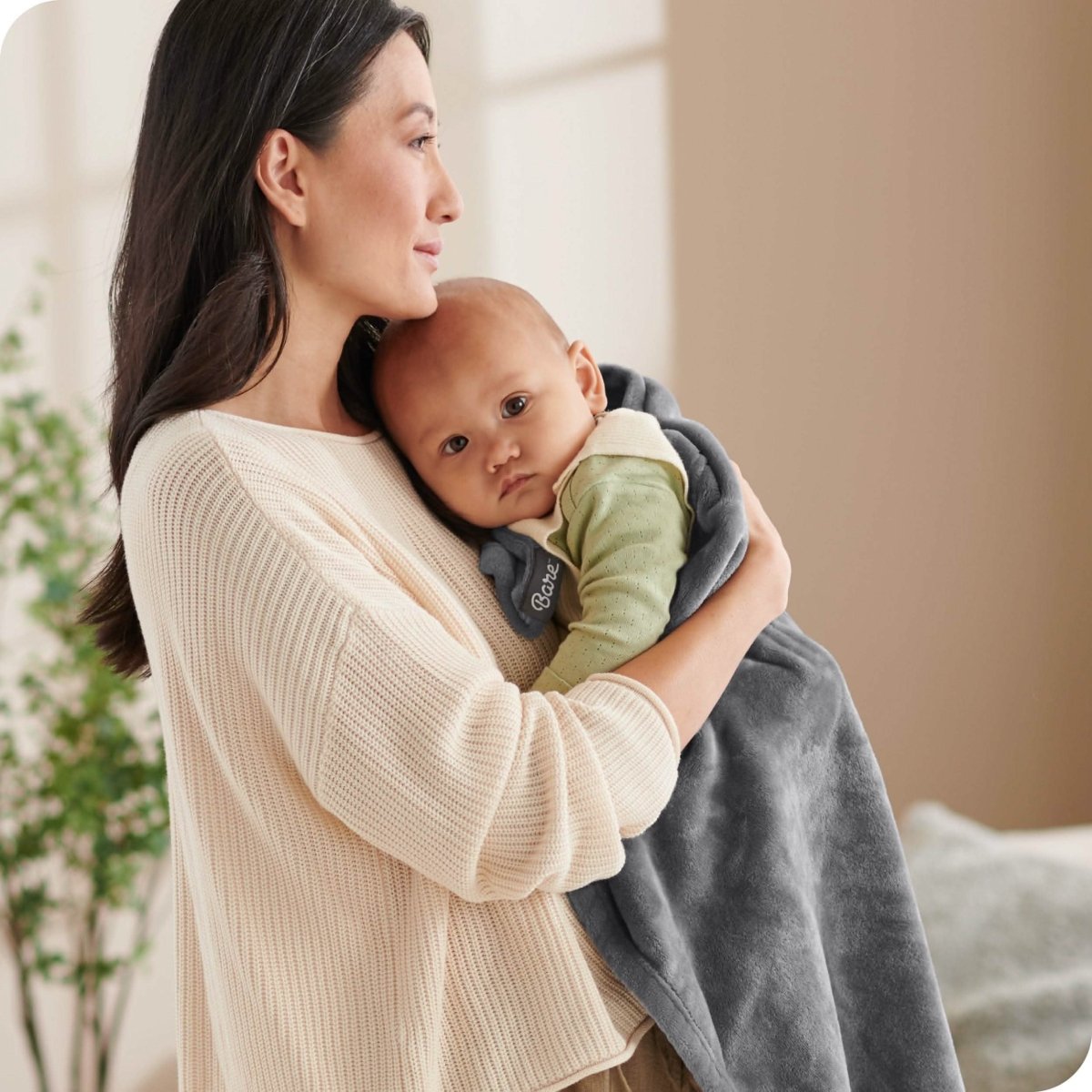 A woman holding a baby wrapped in a microplush blanket