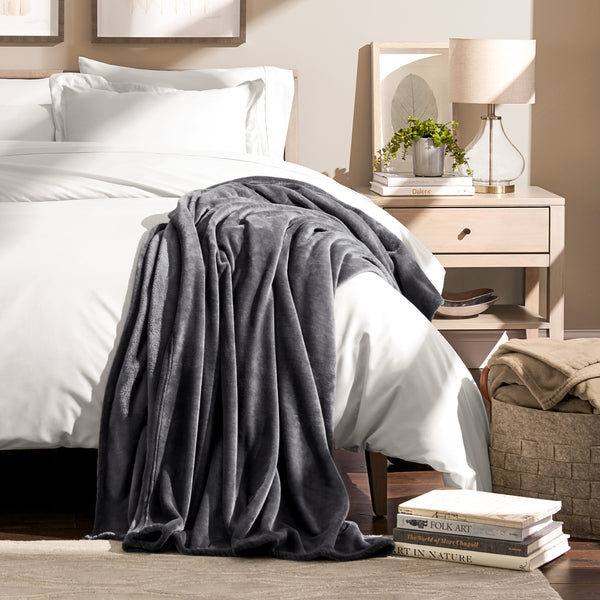 Microplush blanket draped over the corner of a bed