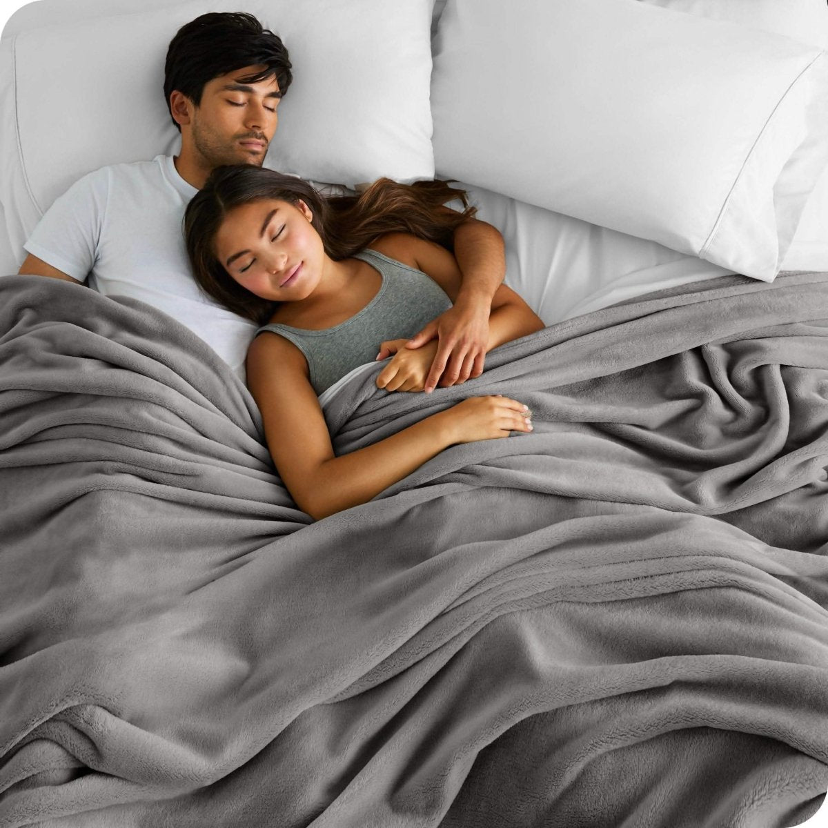 A couple sleeping with covered with a giant microplush blanket