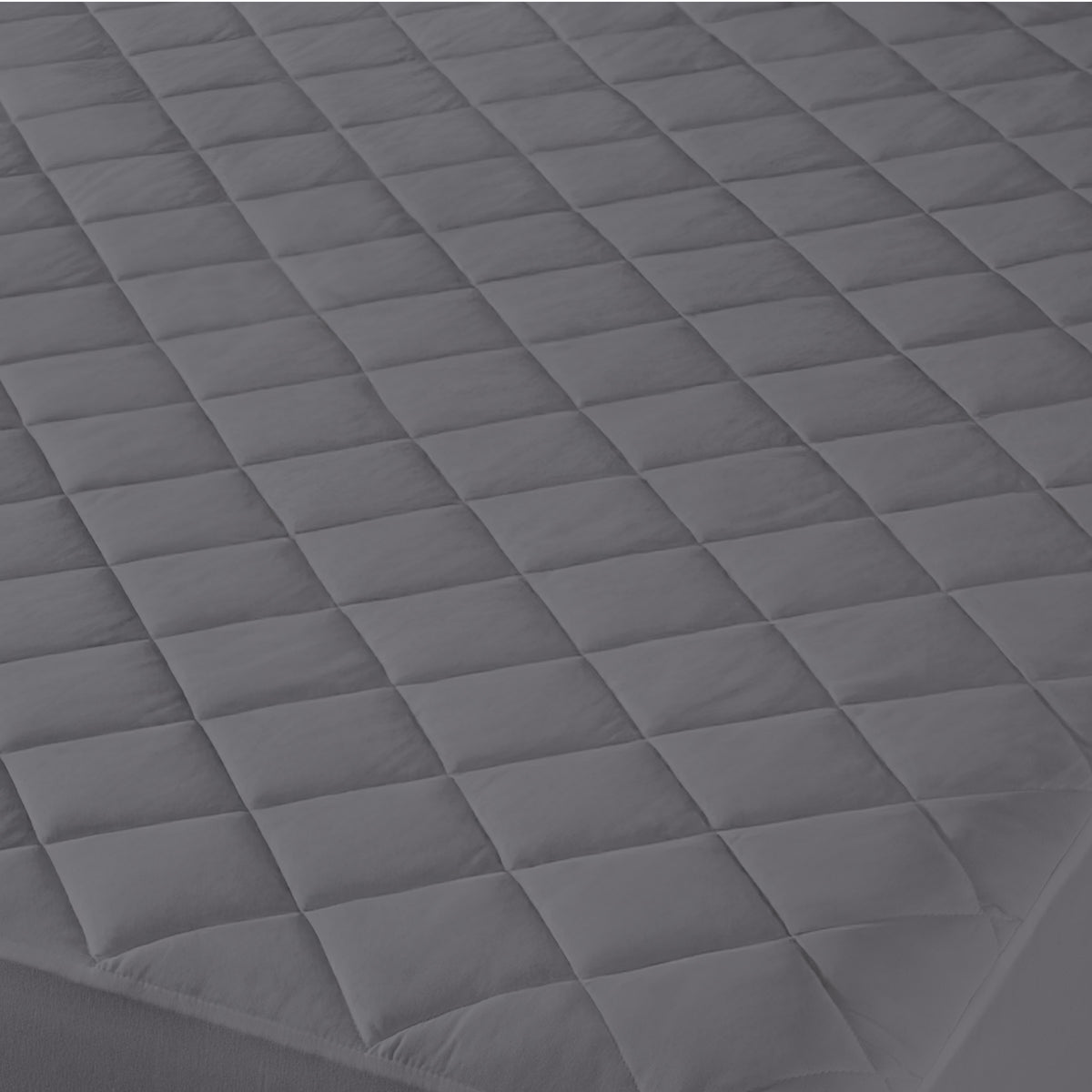 Close-up of a quilted mattress cover with a diamond pattern.