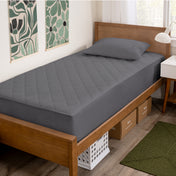 Wooden bed with grey mattress cover in a room with decorative elements.