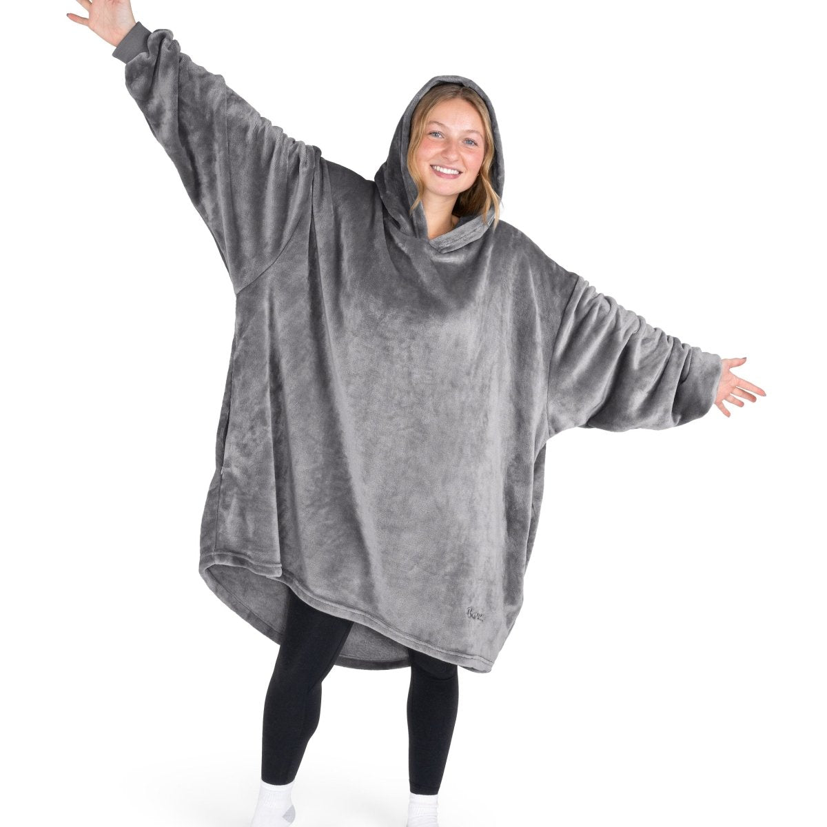 A woman wearing a hooded blanket made of microplush, showcasing comfort and warmth