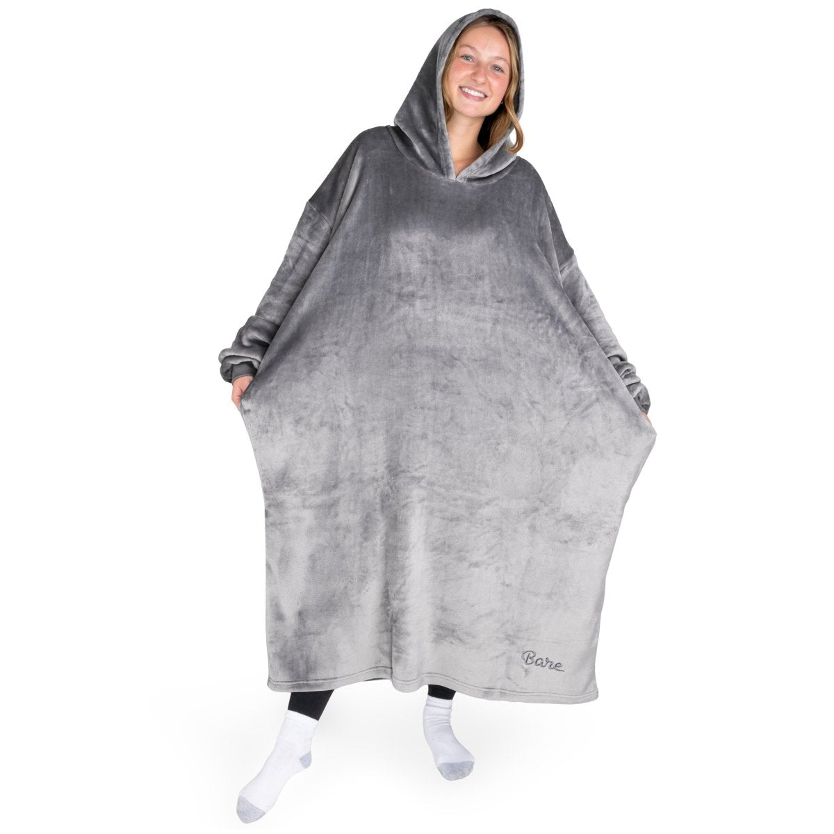 An adult with long microplush wearable blanket on