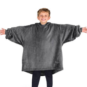 A boy wearing a blanket made of microplush, showcasing comfort and warmth.