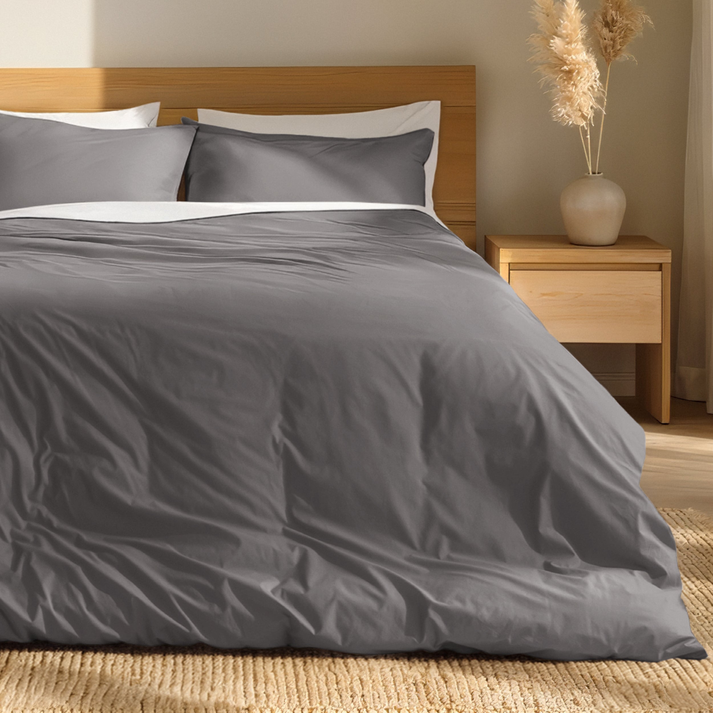 Percale bedding set on a bed with a wooden headboard and nightstand in a bedroom setting.
