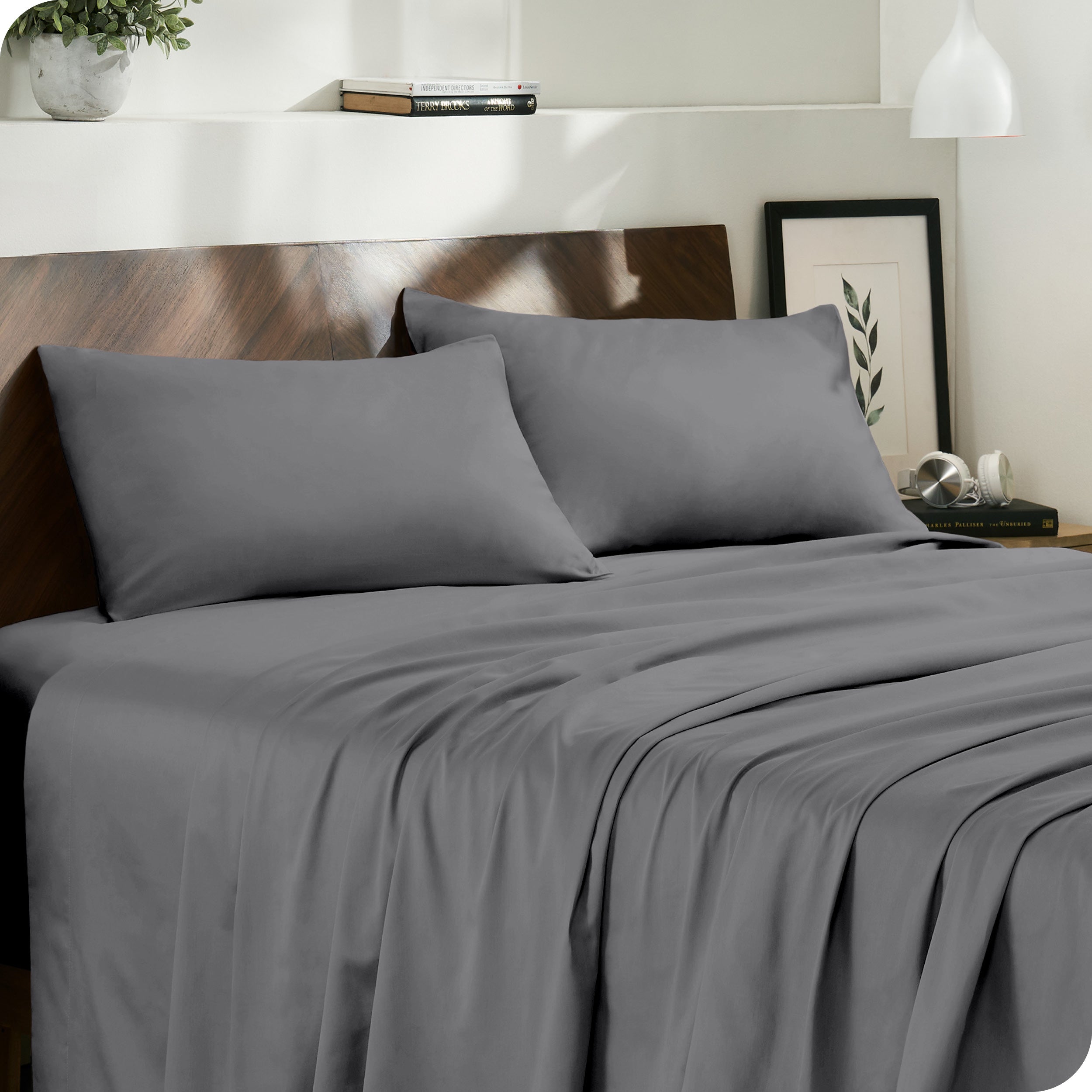 Diagonal view of modern bedroom with sateen sheets and pillowcases on the bed