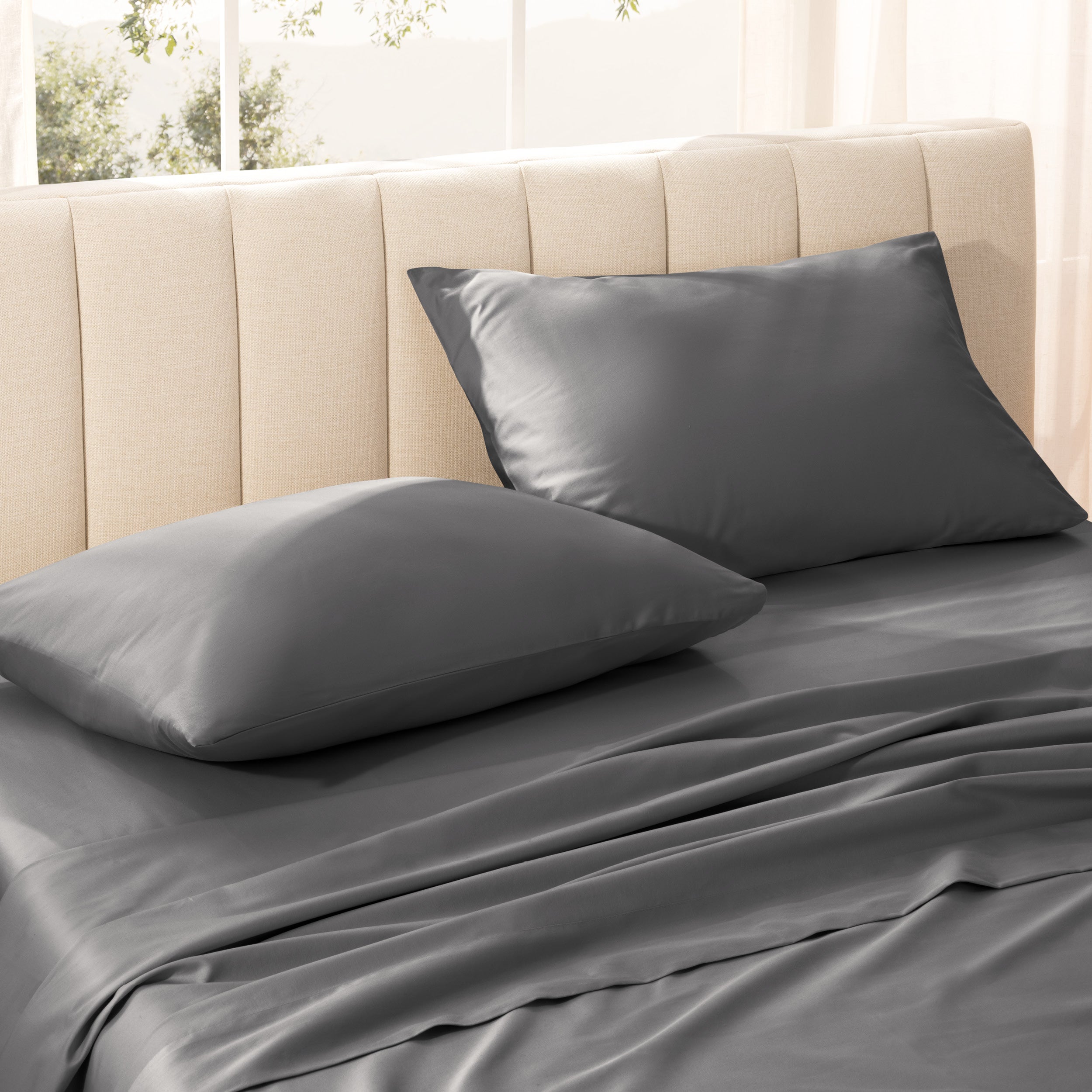 Sateen bedding set on a bed with a beige headboard.