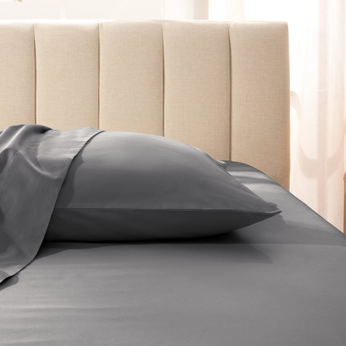 Sateen pillowcase on a bed with a beige headboard