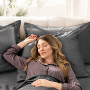Woman sleeping peacefully in a bed made with sateen sheets and pillowcases.