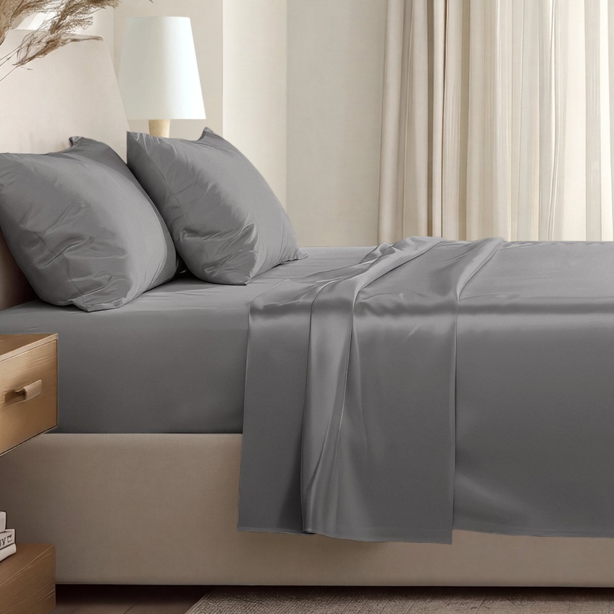 Sateen sheet set on a bed in a softly lit bedroom.
