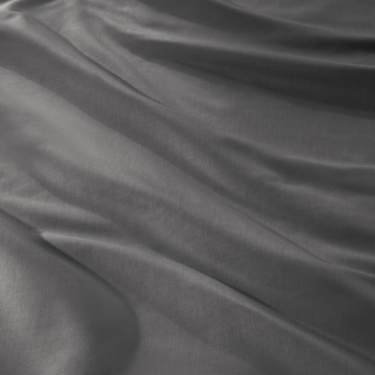 A close-up of draped sateen fabric with soft folds and a smooth texture.