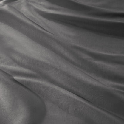 A close-up of draped sateen fabric with soft folds and a smooth texture.