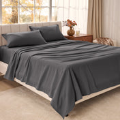Bed sheets on a neatly made bed in a bright bedroom with large windows.