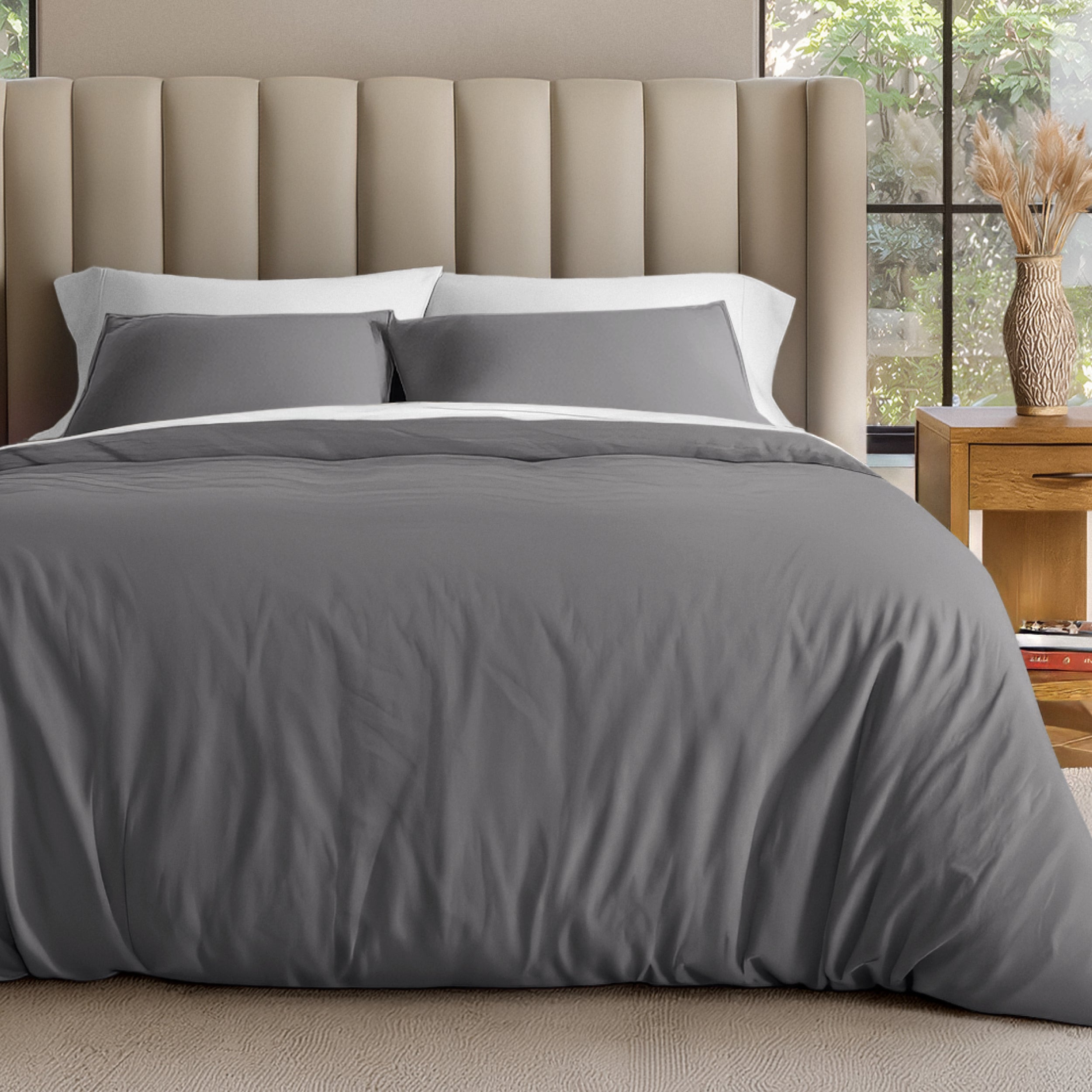 Neatly made bed with organic jersey bedding and pillow shams in a bedroom setting.