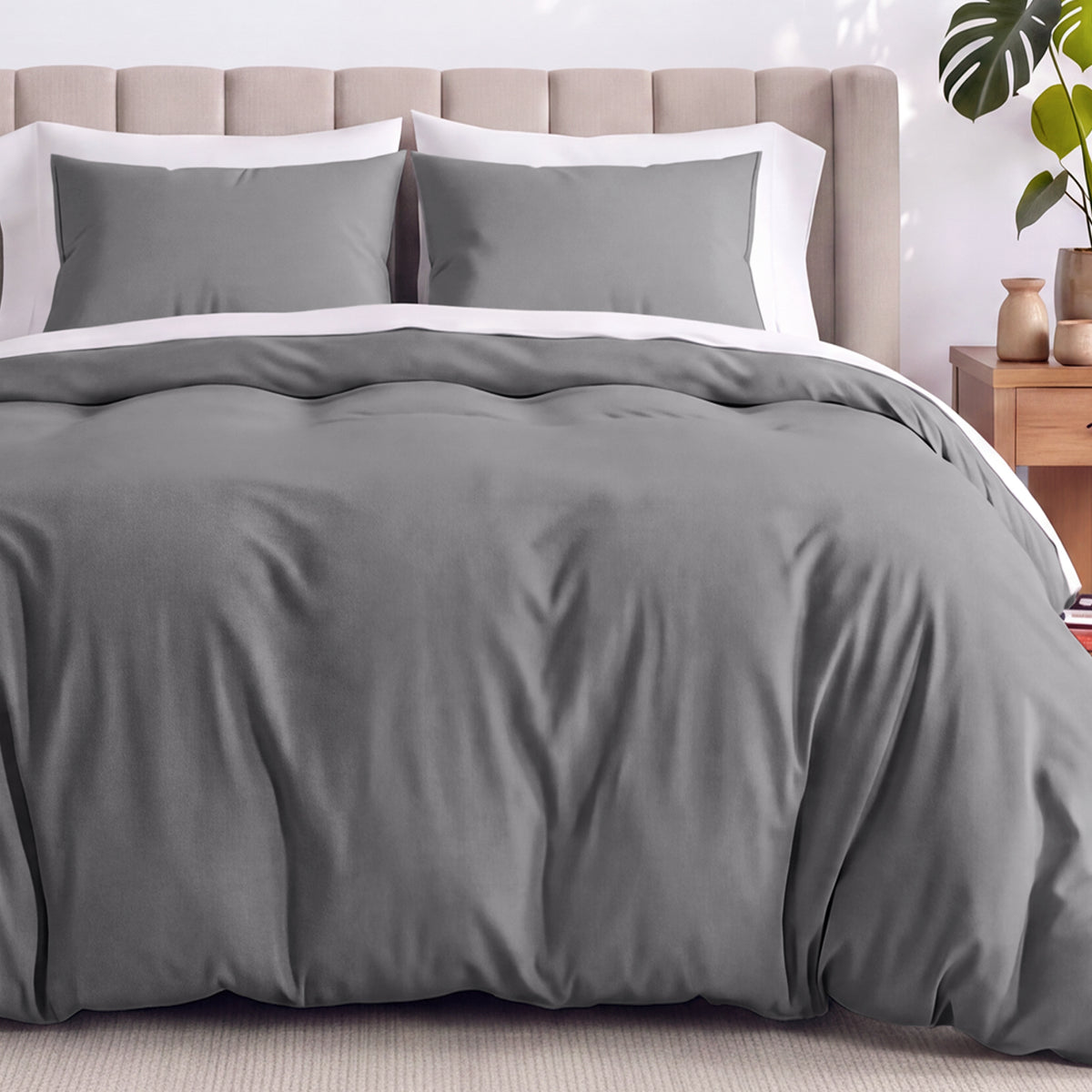 Neatly made bed with organic jersey bedding and pillow shams in a bedroom setting.