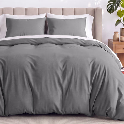 Neatly made bed with organic jersey bedding and pillow shams in a bedroom setting.