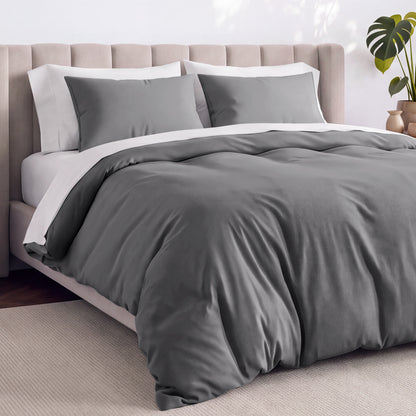 Bed with jersey duvet set against a beige headboard.