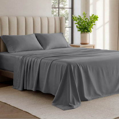 Organic cotton jersey sheets on a bed with a wicker headboard in a room with plants and a lamp.