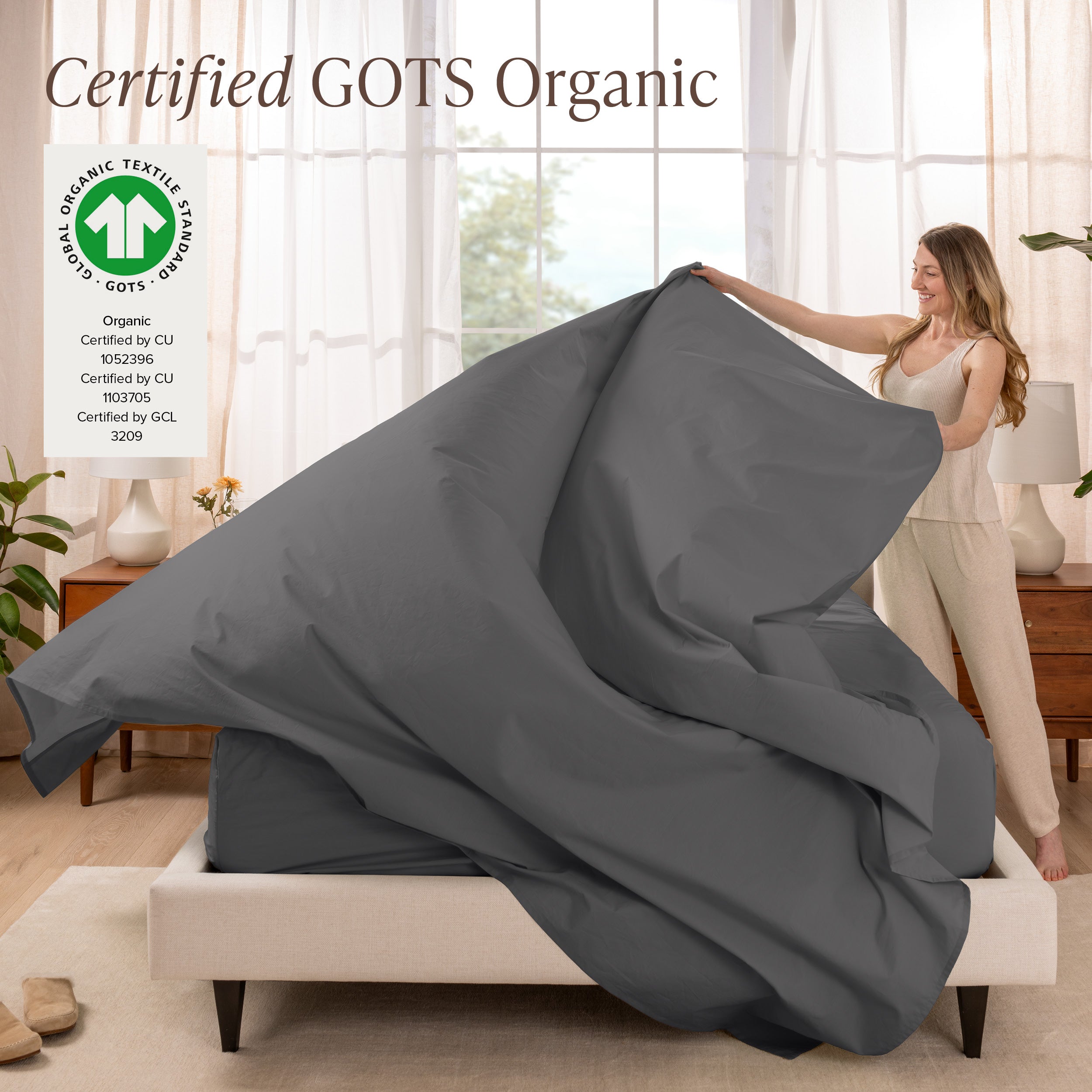 A woman is making a bed with organic cotton percale sheets