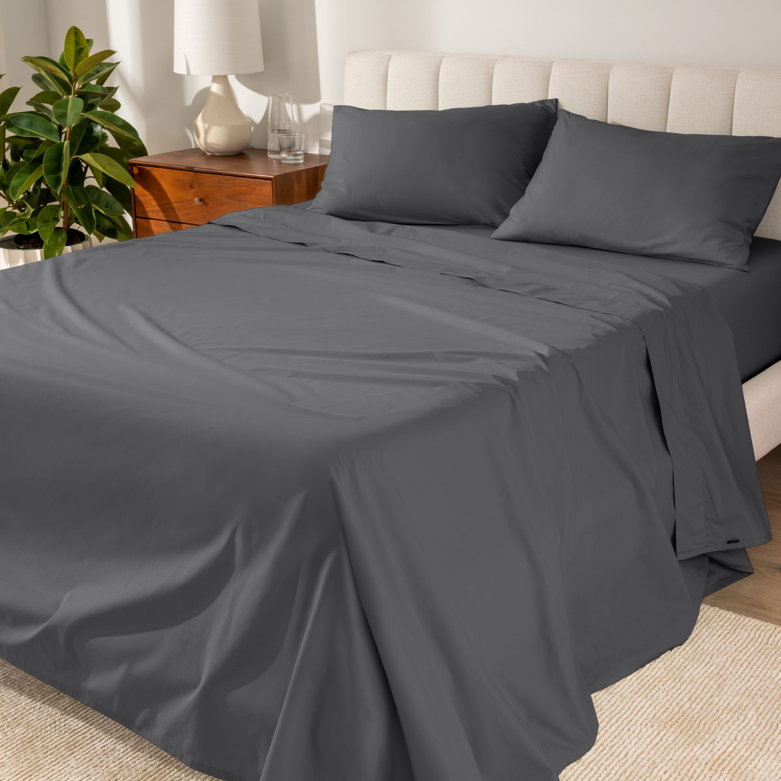 Percale sheets on a bed with a cream colored frame and headboard